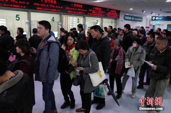 资料图：民众在某医院门诊楼内排队挂号。 中新社记者 殷立勤 摄